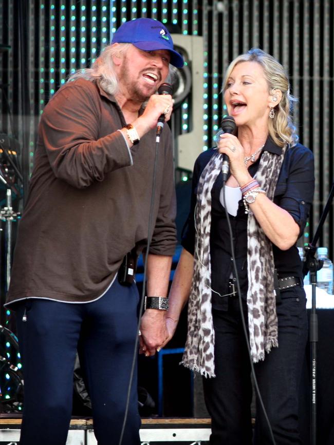 Barry Gibb and Olivia Newton-John singing on stage.