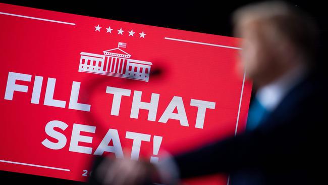 A digital sign showing "Fill That Seat" message is seen as US President Donald Trump speaks during a "Make America Great Again" campaign rally at Harrisburg international airport in Middletown, Pensylvania on September 26.