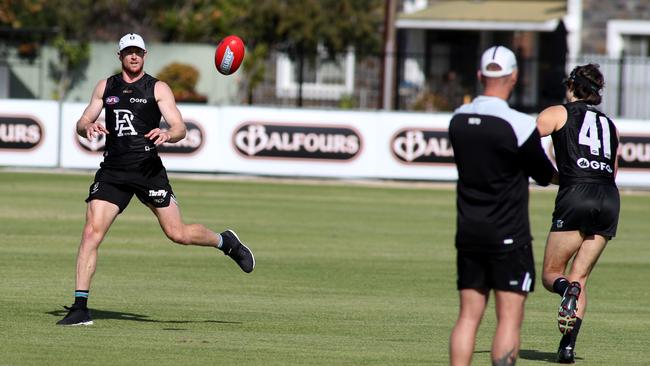 Port Adelaide skipper Tom Jonas receives a handball during a training drill on Friday. Picture: Kelly Barnes