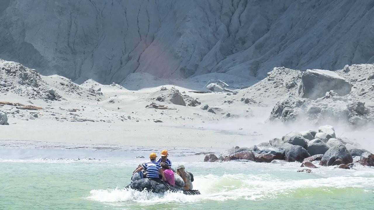 This handout photograph courtesy of Michael Schade shows White Island Tour operators rescuing people minutes after the volcano on New Zealand's White Island erupted. Picture via AFP