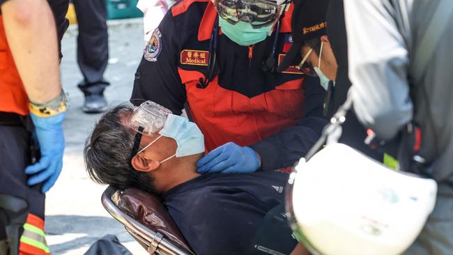 Emergency workers attend a man who had been trapped in a damaged building, in New Taipei City. Picture: CNA via AFP