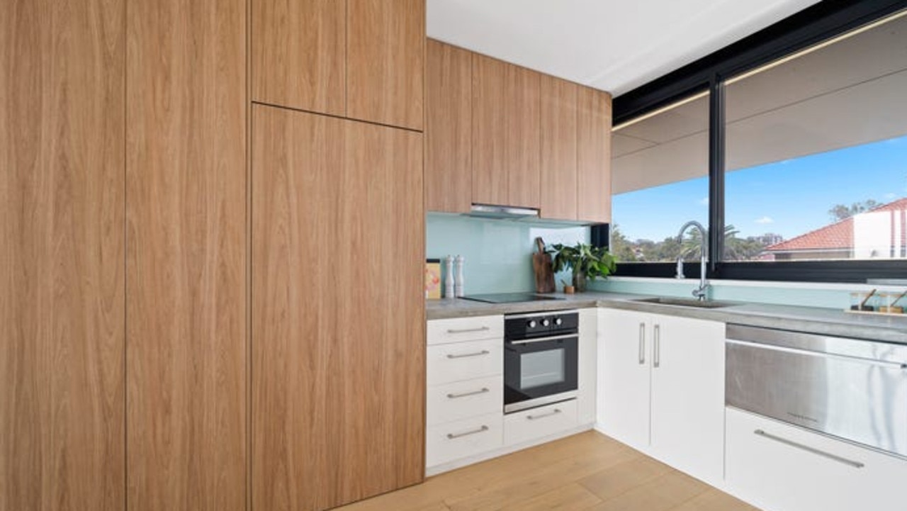 The kitchen with sleek concrete finishes, premium appliances and custom joinery.