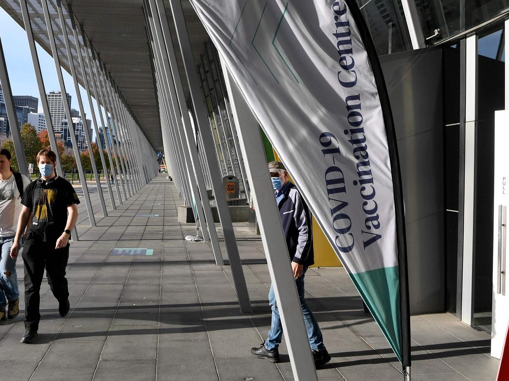 People walk past a Covid-19 vaccination centre in Melbourne as the city records four new locally acquired cases of Covid-19. Picture: William West