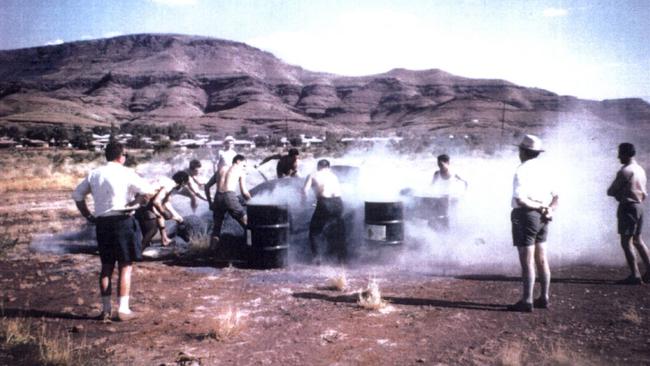 Men shovel raw blue asbestos tailings into drums at an asbestos shovelling competition at Wittenoom, in the Pilbara, WA, in 1962. 