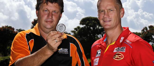 Gold Coast Suns coach Guy McKenna and Paul Fowles with a replica of the coin that he will be tossing at the first Gold Coast Suns game this Saturday in Brisbane.