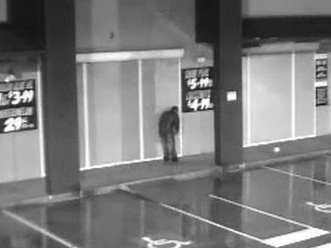 In the first fire a man can be seen cutting the security door of the shop. Picture: NSW Police Media