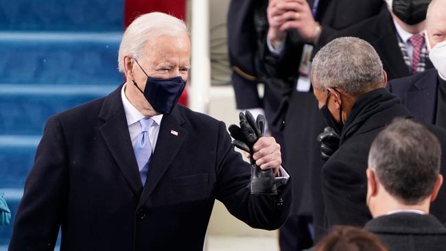 Joe Biden, left, is greeted by former President Barack Obama as he arrives for his inauguration. Picture: Patrick Semansky/AFP