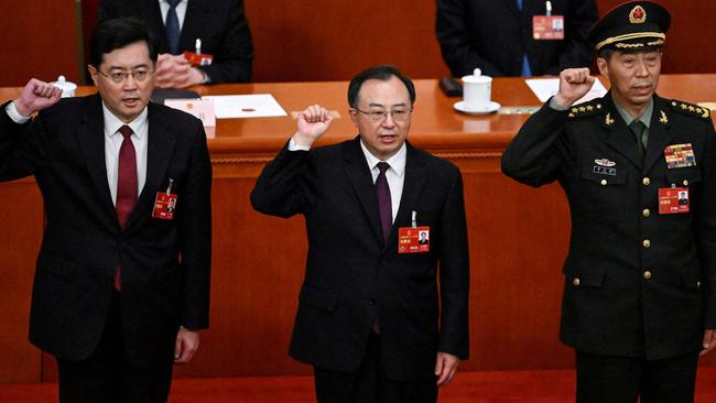 Newly-elected Chinese state councilor Qin Gang (L) and state councilor Li Shangfu (R) swear an oath with state councilor and secretary-general of the State Council Wu Zhenglong (C) after they were elected during the fifth plenary session of the National People's Congress.