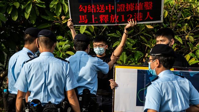 Police last week push back pro-democracy activist Joshua Wong as he protests for the 12 Hong Kongers intercepted by the Chinese coastguard. Picture: AFP