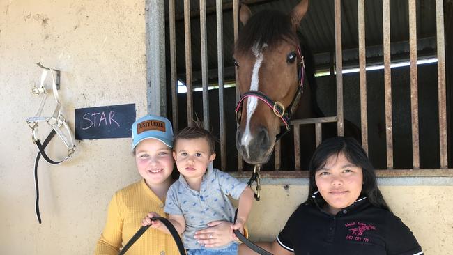 Grafton trainer Dwayne Schmidt's Grafton Guineas hopeful Hyperion Star with Mackenzie Dowse (9), Darby Schmidt (18 months) and Nevaeh Tindoy (9).