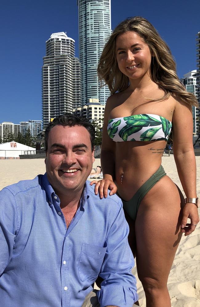 Jason Costigan poses with a bikini model on the Gold Coast.