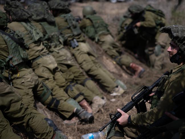 IDF soldiers guard an area around Kibbutz Kfar Aza where dozens of civilians were killed by Hamas militants near the border with Gaza. (Photo by Alexi J. Rosenfeld/Getty Images)