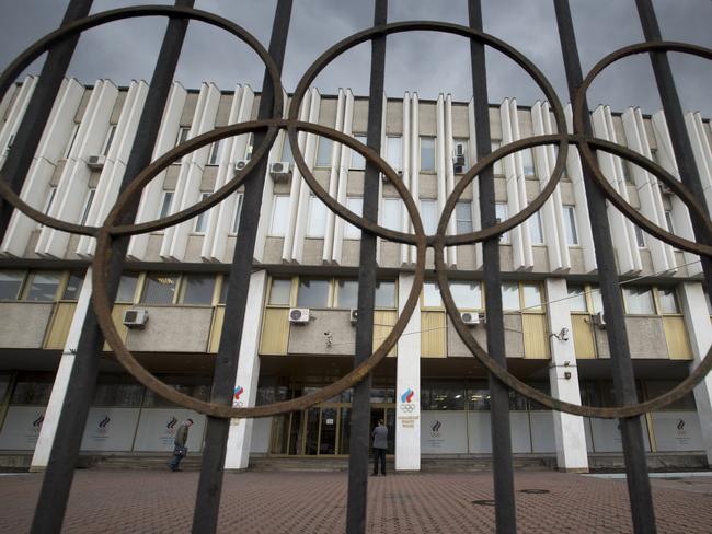 People walk in front of the Russian Olympic Committee building in Moscow, Friday, Nov. 13, 2015. In an effort to avoid a ban from track and field, Russia offered “broad cooperation” on doping reforms on Friday, including the creation of a new anti-doping agency. (AP Photo/Pavel Golovkin)