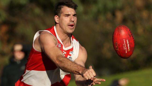 Glenroy gun Travis Dulic fires off a handball. Picture: Hamish Blair