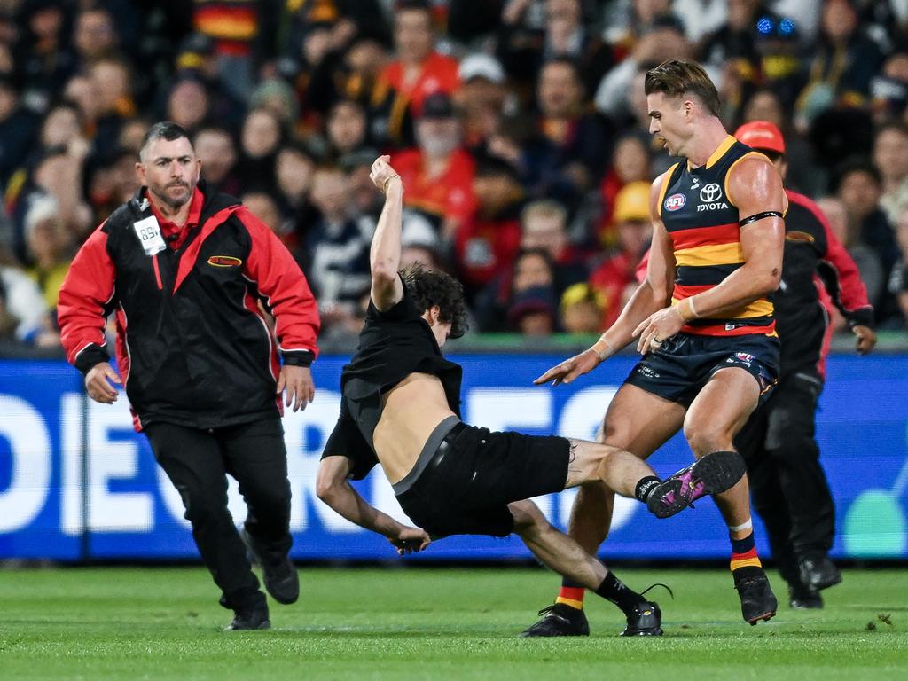 Ben Keays knocks a ground invader to the ground at the Adelaide Oval on Friday night. Picture: Mark Brake/Getty Images.