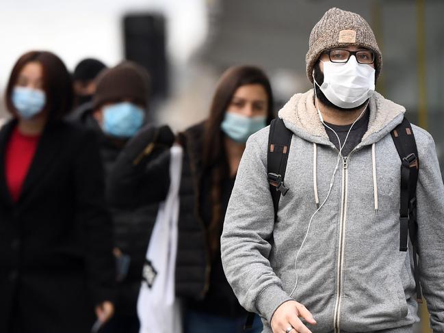 Commuters walk past Melbourne's Flinders Street Station on July 23, 2020 on the first day of the mandatory wearing of face masks in public areas as the city experiences an outbreak of the COVID-19 coronavirus. (Photo by William WEST / AFP)