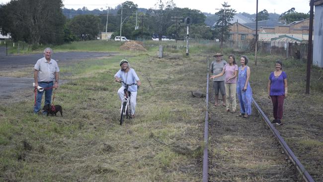 TOOT and Northern Rivers Railway Action Group believe there is enough space in the rail corridor to place the Tweed Rail Trail next to instead of on top of the old train tracks. Pictured is members John Watson with Tazi the dog, Jozie O'Callaghan (on the bike), and Peter Stephens, Lydia Kindred, Dian Flint and Beth Shelley on the tracks.