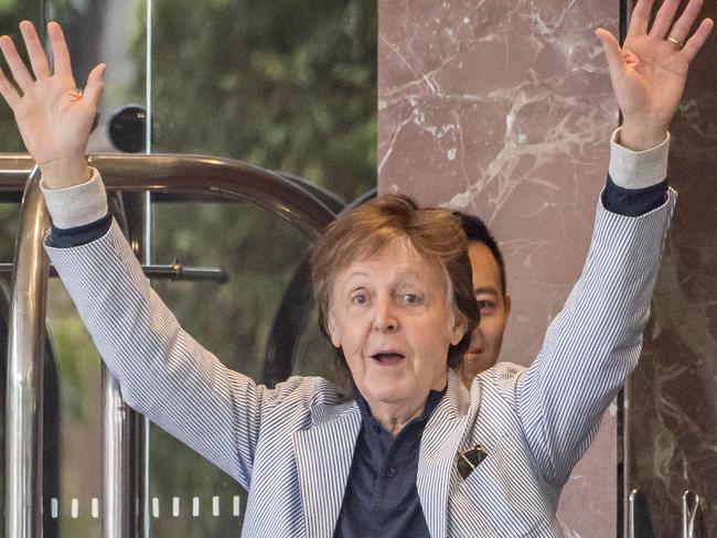 Sir Paul McCartney leaves Melbourne's Park Hyatt Hotel enrol to sound check for his concert tonight, fans surround the entrances to catch a glimpse. Picture: Jason Edwards