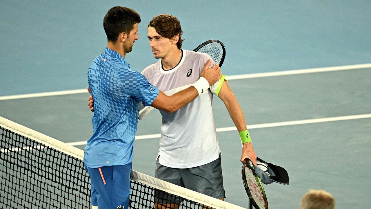 Novak Djokovic embraces Alex de Minaur at the net. Photo by ANTHONY WALLACE / AFP.
