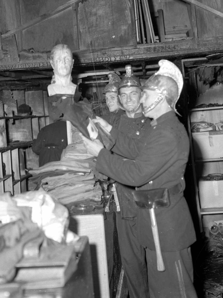 Firemen trying on the old brass helmets at Basil Buss Store, Fortitude Valley, in 1957. Picture: Bob Millar Snr