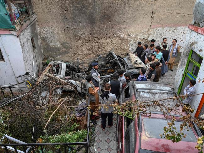 Afghan residents and family members of the victims gather next to a damaged vehicle after a US drone air strike in Kabul. Picture: AFP