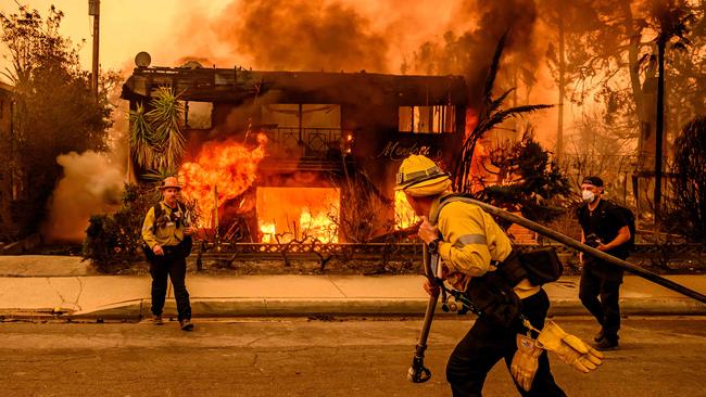 Firefighters work the scene as an apartment building burns during the Eaton fire in the Altadena area of Los Angeles county. Picture; AFP