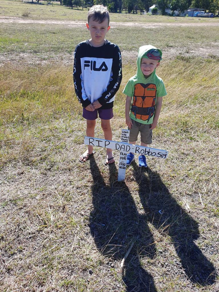 The children of Robert Sim created a cross and wrote a tribute dedicated to their beloved father on it, before placing it at the crash site on Childers Rd.