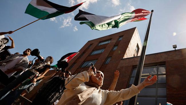 Pro-Palestinian demonstrators use a large Palestinian flag to block the doors to Bell Hall.