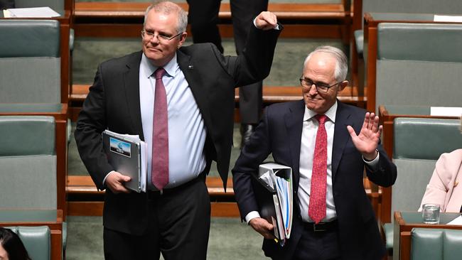 Treasurer Scott Morrison points to Prime Minister Malcolm Turnbull announcing he has retained power as they walk into Question Time yesterday. Picture: AAP