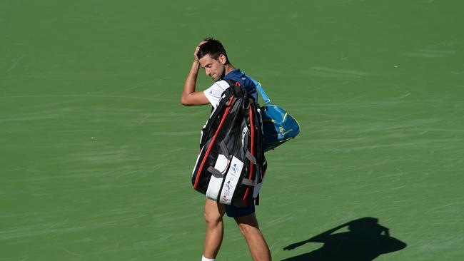Novak Djokovic of Serbia walks off the court dejected.