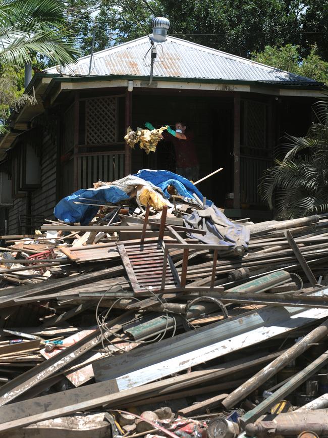 A home owner throws debris from his house in Strong St in the inner western suburb of Brisbane on Monday, January 17, 2011. More than 75 per cent of Queensland was declared a disaster zone after weeks of flooding in regional and metropolitan areas.
