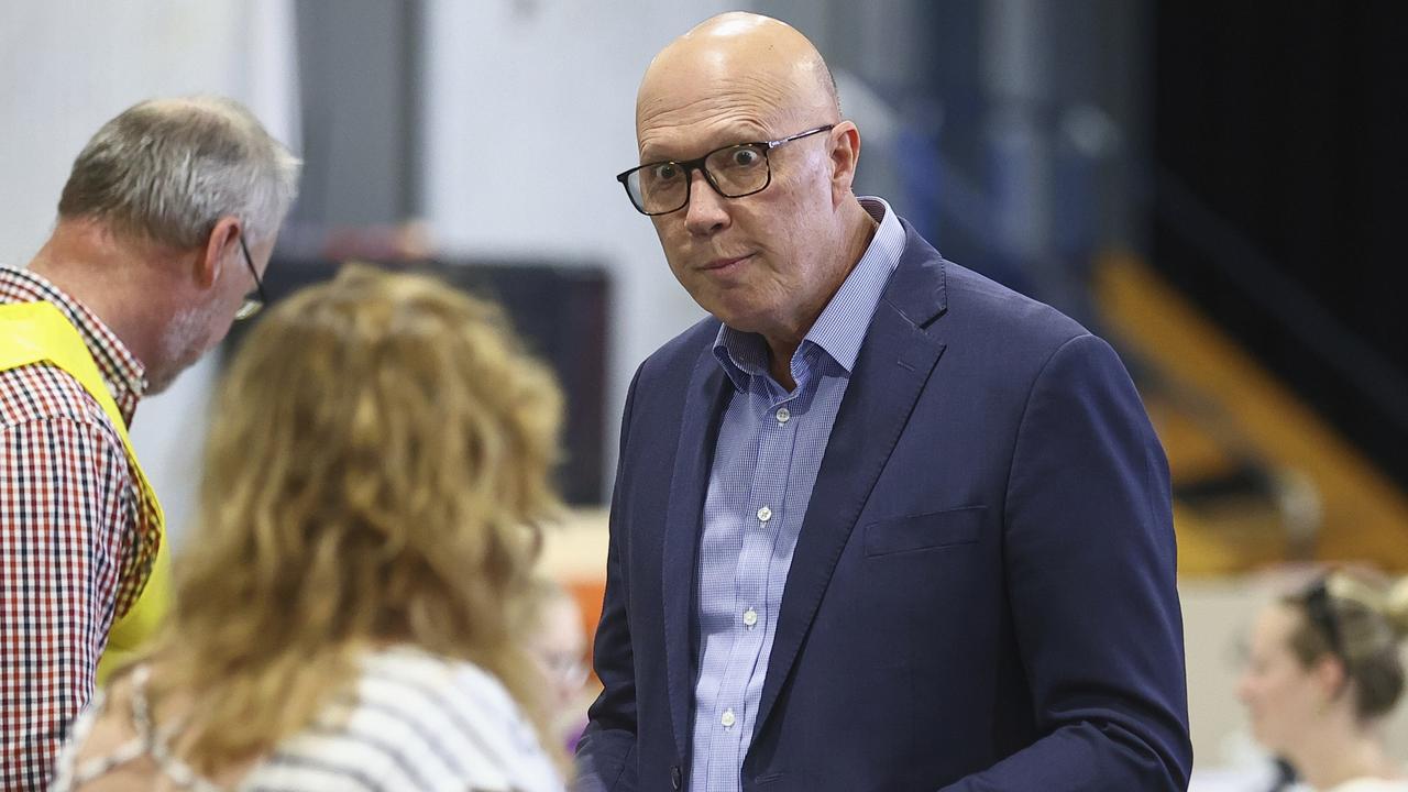 Australian Liberal Party leader Peter Dutton talks with an election official as he prepares to vote in his electorate in Brisbane, Australia. Picture: AP Photo/Pat Hoelscher