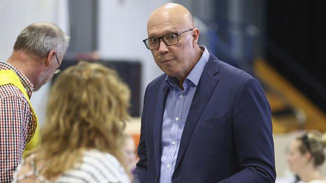 Australian Liberal Party leader Peter Dutton talks with an election official as he prepares to vote in his electorate in Brisbane, Australia. Picture: AP Photo/Pat Hoelscher