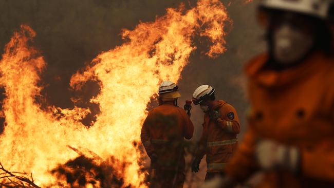 A Tasmania Fire Service crew putting out a spot fire on Donnellys Rd at Geeveston this week. Picture: LUKE BOWDEN