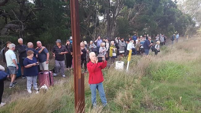 Shaken passengers stand by the side of the tracks. Picture: Richard Sherman