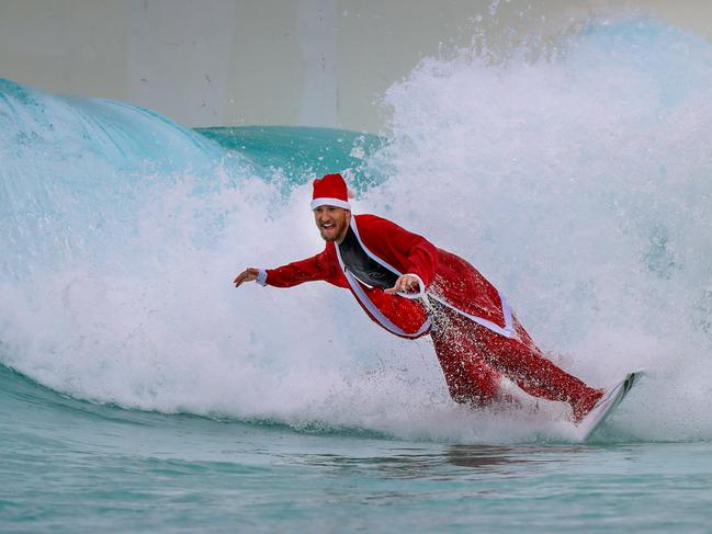 Santa catches a wave at URBNSURF Melbourne.