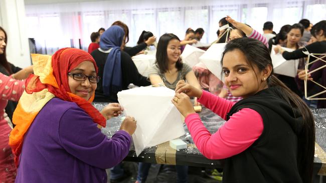 Tahia Rahman and Harry Sidhu work on a lantern project while attending the Adult Migrant English Program at the Brisbane Mt Gravatt TAFE campus. Picture: Josh Woning.