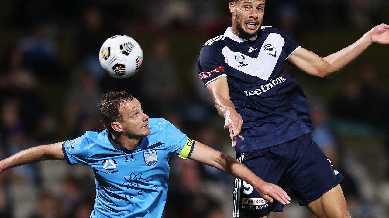 Victory player Rudy Gestede is challenged by Alex Wilkinson of Sydney FC.