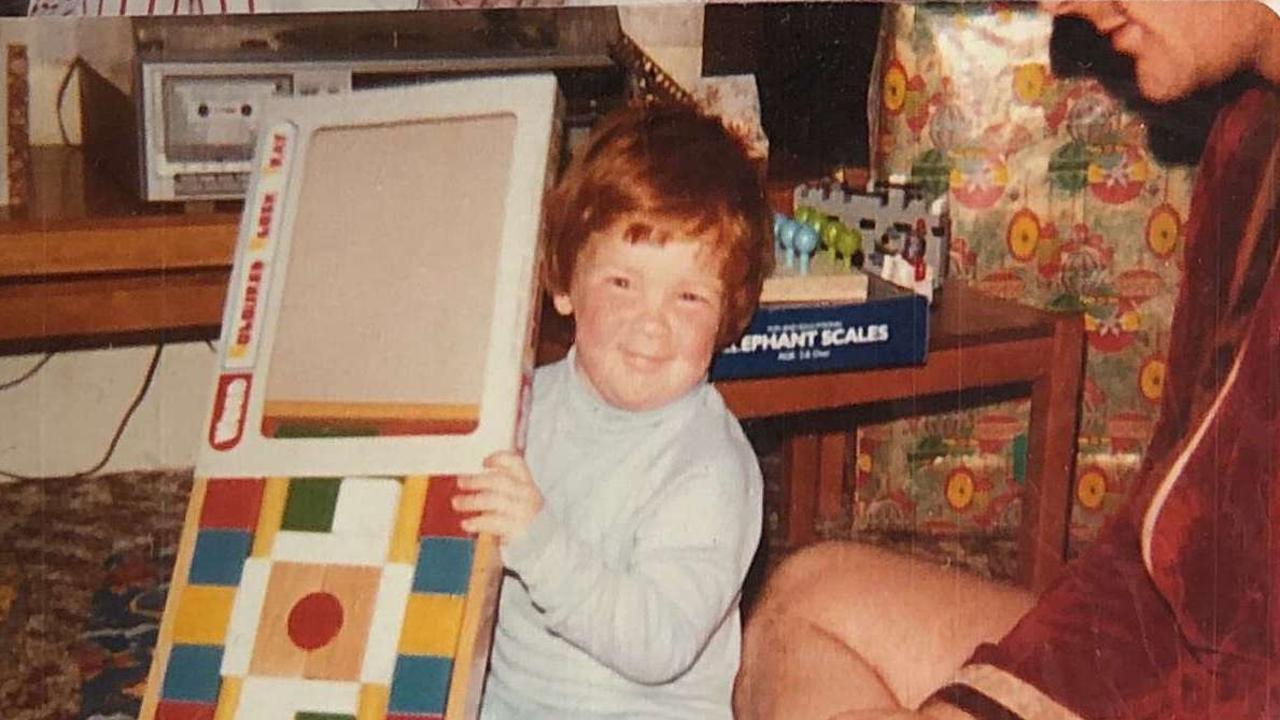 Dad watches as JC opens a present on Christmas morning, 1984.