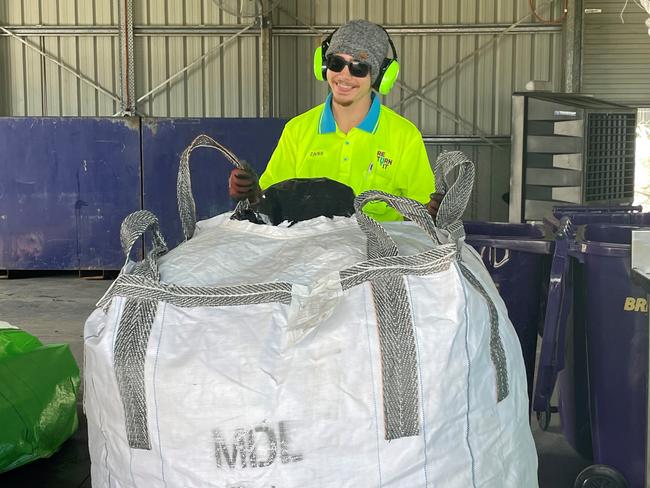 Staff member Zavier Edwards with a full bag of containers.