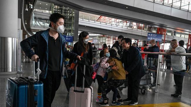 Passengers walk through the arrivals hall for international flights at the Capital International Airport in Beijing on March 14, 2023.