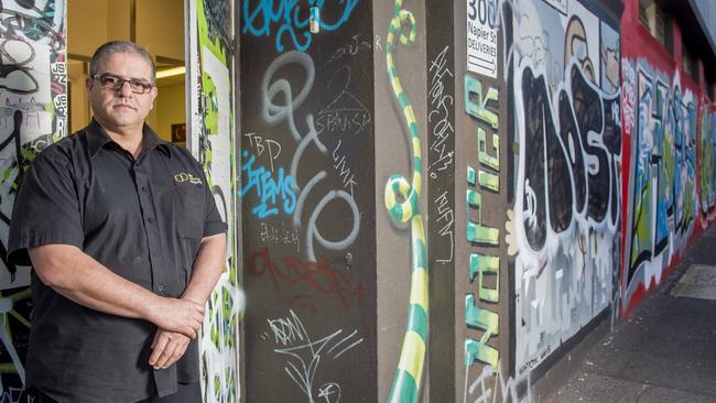 Sam Conti business owner of the Catering Company in front of his business where the walls have been a constant target of tagging. The City of Yarra are reducing the funding provided for graffiti removal.