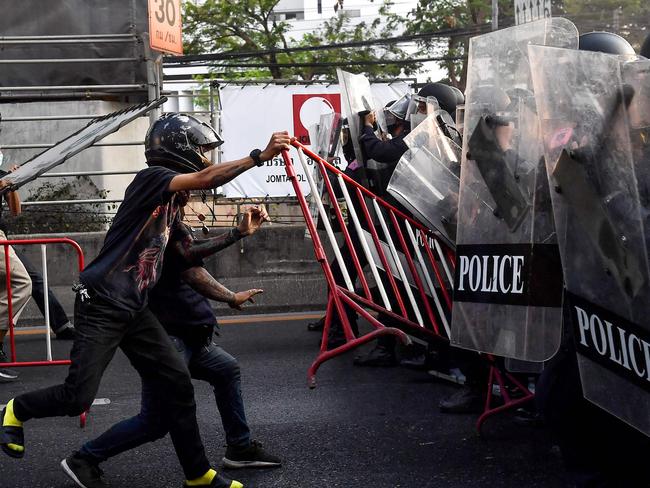 Thai pro-democracy protesters throw a barricade at riot police in Bangkok, in the area where Myanmar migrants were demonstrating: Picture: Lillian Suwanrumpha/AFP