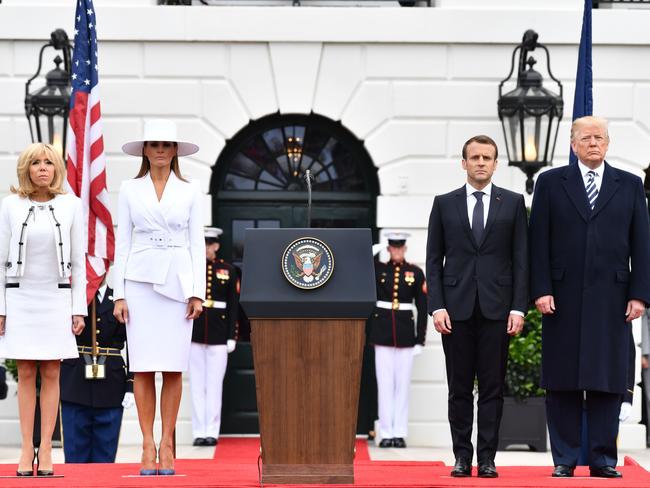 Melania Trump looked serious in white, beside an equally sober Brigitte Macron and their presidential husbands. Picture: AFP/Nicholas Kamm