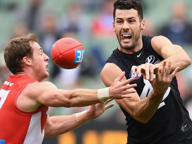 Simon White gets away a handball for the Blues.