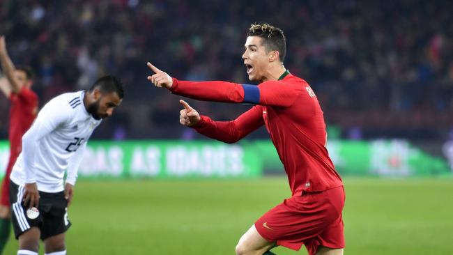 Portugal's forward Cristiano Ronaldo (R) reacts after scoring a goal during the international friendly football match between Portugal and Egypt