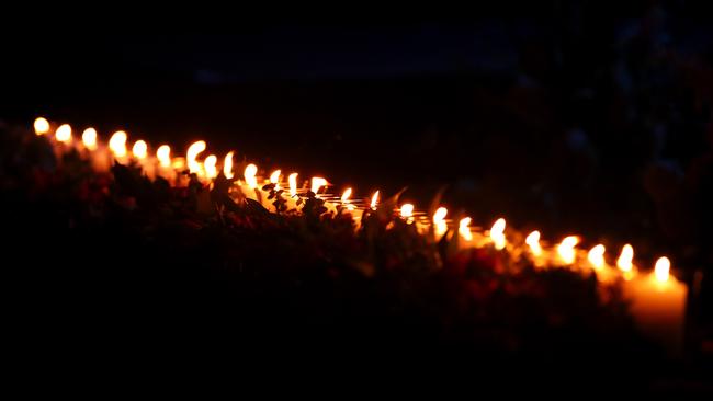 Candles representing those deceased flicker after being lit by family members. Cameron Spencer/Getty