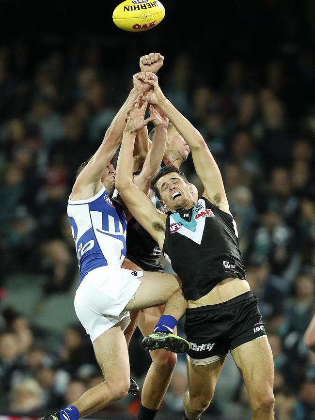 Ryan Burton gets a knee in the back from North Melbourne’s Kayne Turner during a contest on Friday night. Picture: Sarah Reed