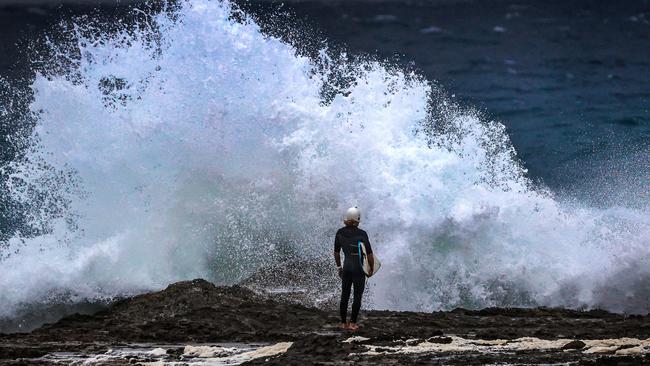 Wet weather and windy conditions on the Gold Coast as surfer enter the rough surf at Snapper Rocks. Picture: NIGEL HALLETT