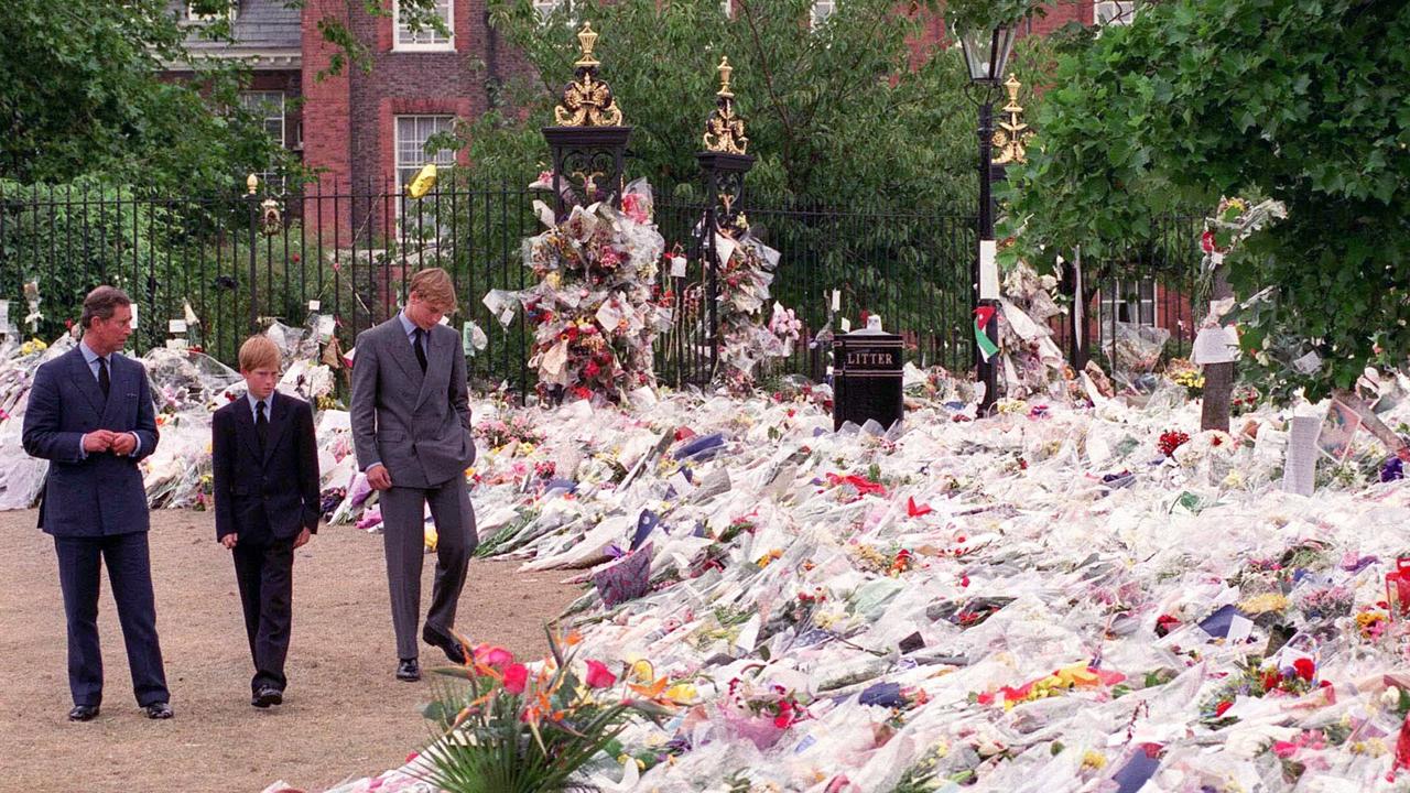 The Prince of Wales with William and Harry looking at floral tributes left at Kensington Palace following the death of Diana. Picture: Anwar Hussein